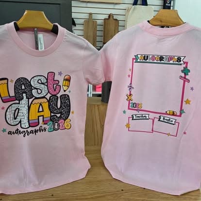 Two custom tees displayed on a table.